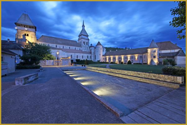 Photo de Chambon-sur-Voueize illuminé au crépuscule, avec son ancien monastère et son abbatiale romane dédié à sainte Valérie; une commune labellisée Plus Beaux Villages de France, dans le département de la Creuse, en région Nouvelle-Aquitaine.