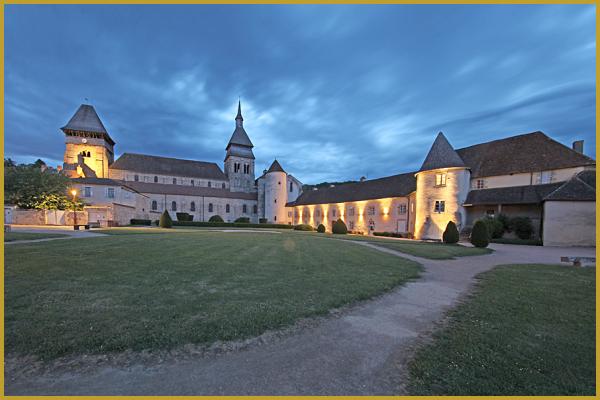 Photo du jardin du monastère de Chambon-sur-Voueize à la tombée de la nuit, avec l'ancien monastère et l'abbatiale Sainte-Valérie; une commune située aux confins du Limousin, du Bourbonnais et de l'Auvergne, au coeur de la vallée de la Tardes.